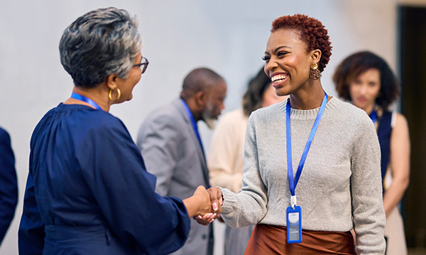 A photo of two women shaking hands at a conference