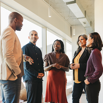 A group of five individuals circled together in discussion